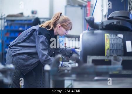 Femmina meccanico auto lavoro in officina di riparazione Foto Stock