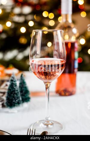 Bicchiere di vino blushed nella parte anteriore della decorazione di Natale Foto Stock