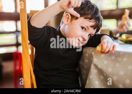 Ritratto di un ragazzo di mangiare churros a tavola in casa Foto Stock