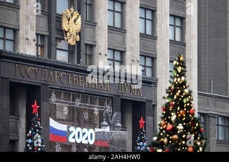 Emblema russo sul parlamento russo a Mosca, alberi di Natale e luci festose di fronte all'entrata. Anno Nuovo 2020 decorazioni Foto Stock