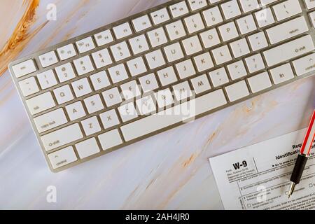 Applicazione di IRS Form W-9, richiesta di codice identificativo del contribuente la certificazione con la penna sulla tastiera di un computer Foto Stock