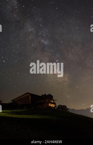 Via Lattea oltre cottage di legno nelle Alpi, Austria Foto Stock