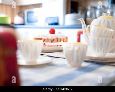 Una spugna di Victoria su un tavolo in una luminosa cucina. Foto Stock