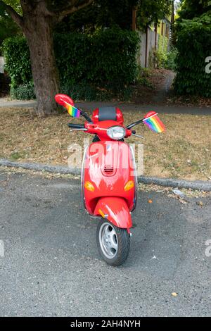 Scooter ciclomotore rosso con bandiere arcobaleno a Seattle, Washington, Stati Uniti Foto Stock