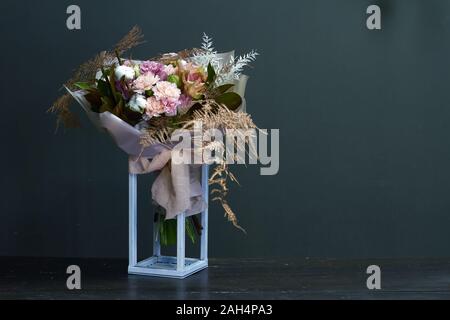 Bouquet originale in stile vintage su una superficie di legno in un geometrico di un supporto in metallo, saluto in background o di concetto Foto Stock