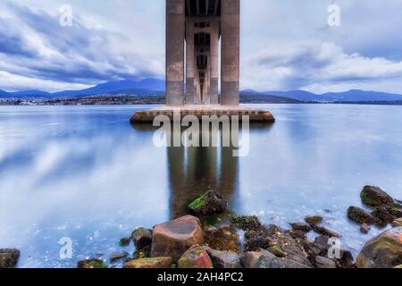 Sotto il Tasman ponte attraverso il fiume Derwent in Hobart all'alba quando le nuvole e le luci riflettono ancora in acque. Foto Stock