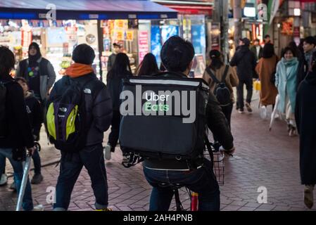 American online cibo di ordinazione e di piattaforma di consegna lanciato da Uber, Uber mangia, lavoratore visto in sella alla sua bicicletta in Tokyo, Giappone. Foto Stock