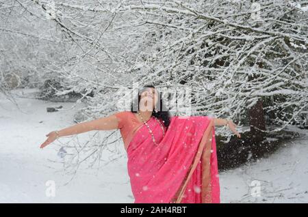 Tradizionalmente condita fiducioso donna indiana godendo di nevicata Foto Stock