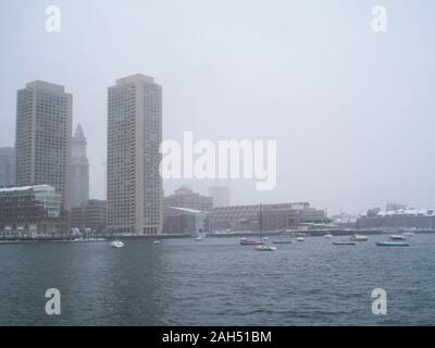 Città e barche in acqua durante una tempesta di neve con cielo nuvoloso. Foto Stock