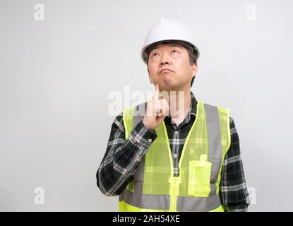 Una mezza età Asian lavoratore che è pensare attentamente su qualcosa. Foto Stock