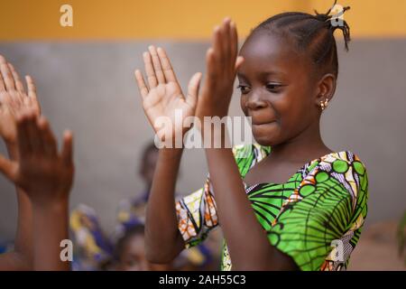 Giovane ragazza africana concentrandosi sulla sua mano battimani gioco
