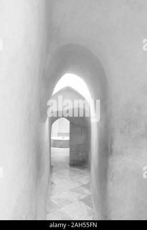 Bianco e nero stretto supportico di età compresa tra edificio con shabby Lisce pareti e pavimento piastrellato Foto Stock