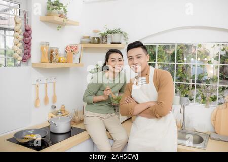 Felice coppia giovane mangiare e parlare in cucina Foto Stock