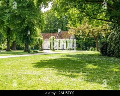 Prato verde, la casa e gli alberi in Minnewaterpark in Bruges, Fiandre Occidentali, Belgio Foto Stock