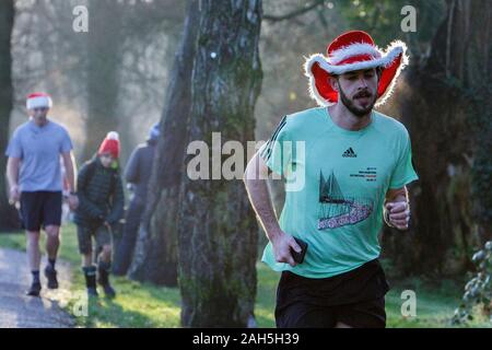 Chippenham, Wiltshire, Regno Unito. 25th dicembre 2019. Un corridore è ritratto mentre prende parte ad un parkrun 5km di Natale di mattina presto in Monkton Park, Chippenham, Wiltshire. 400-500 persone hanno partecipato all'evento con molti vestirsi in abito elegante. Credito: Lynchpics/Alamy Live News Foto Stock