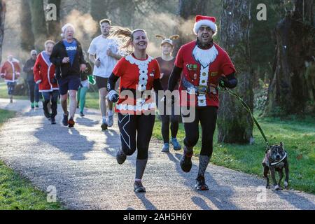 Chippenham, Wiltshire, Regno Unito. 25th dicembre 2019. I corridori in vestito di fantasia sono ritratti mentre prendono parte ad un parkrun 5km di Natale di mattina presto in Monkton Park, Chippenham, Wiltshire. 400-500 persone hanno partecipato all'evento con molti vestirsi in abito elegante. Credito: Lynchpics/Alamy Live News Foto Stock