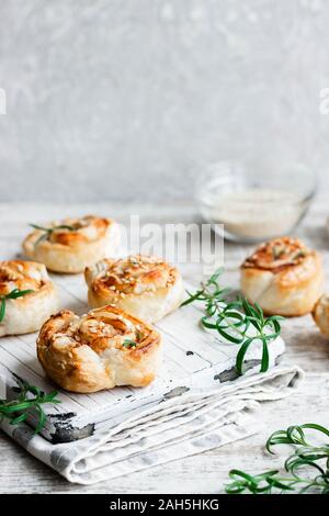 Lumache di amaro e pasta sfoglia con pancetta e semi di sesamo. Confortevole e semplice cibo. Foto Stock