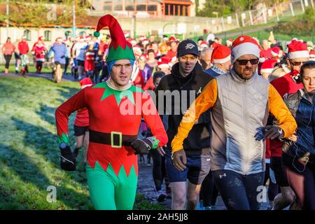 Chippenham, Wiltshire, Regno Unito. 25th dicembre 2019. I corridori in vestito di fantasia sono ritratti mentre prendono parte ad un parkrun 5km di Natale di mattina presto in Monkton Park, Chippenham, Wiltshire. 400-500 persone hanno partecipato all'evento con molti vestirsi in abito elegante. Credito: Lynchpics/Alamy Live News Foto Stock