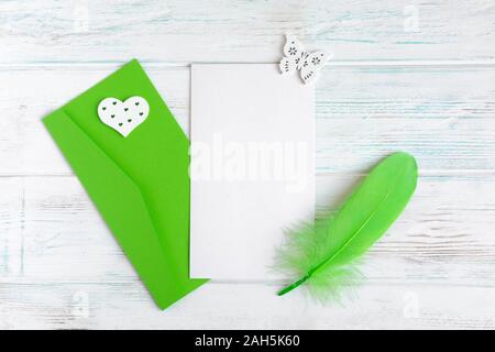 Telaio per il biglietto di auguri testo. Banner con buste, penna e una cartolina su un bianco sullo sfondo di legno. Progettazione del layout di base per il biglietto di auguri mamma, ragazza, Foto Stock