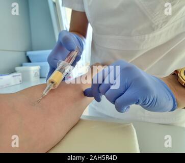 Il medico prende il sangue da una vena per l'analisi Foto Stock