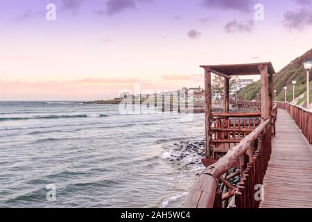 Il Boardwalk a Gonubie beach nella zona est di Londra del Capo orientale, Sud Africa al tramonto. Bellissimo paesaggio marino sfondo Foto Stock