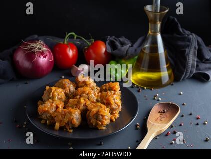 In casa la carne gnocchi di patate con pomodoro STIR FRY, con gli ingredienti per la salsa sul scuro dello sfondo rustico, vista orizzontale Foto Stock