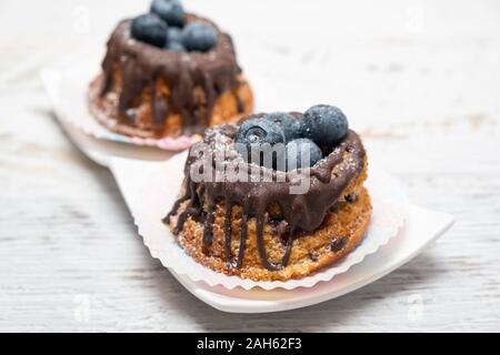 Pane appena sfornato muffin ai mirtilli con topping di cioccolato Foto Stock