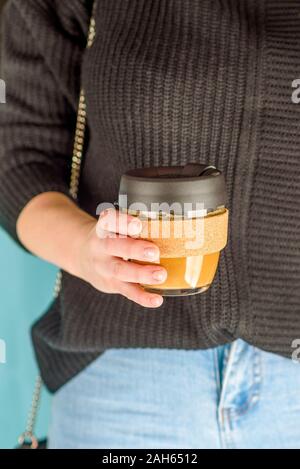 Close-up di giovane donna di contenimento di vetro riutilizzabili tazza di caffè. Rifiuti Zero concetto. Portare la propria tazza. Eco Cup. Foto Stock