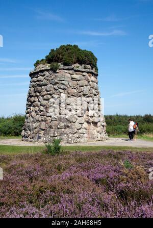 I visitatori di leggere la targa commemorativa sul monumento al 'Gallant montanari" sul sito del 1746 Battaglia di Cullodon Moor, in cui British troo Foto Stock