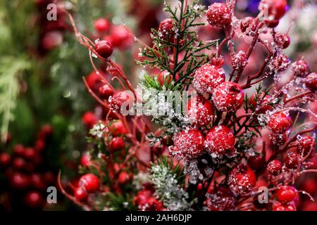 La disposizione del Natale berry holly o rametti di leccio, palle rosse come una casa decorazioni per il Natale e Capodanno. Foto Stock