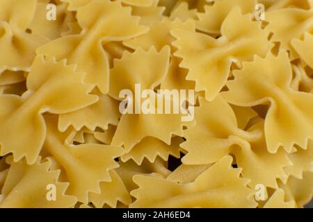 Sullo sfondo di alcune farfalle di pasta a forma di prua. La texture. pattern Foto Stock