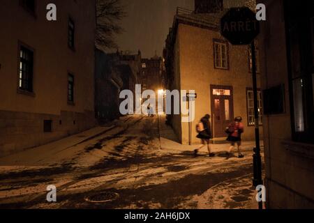 Due ragazze in esecuzione attraverso la neve di notte, Old Quebec City, in Canada Foto Stock