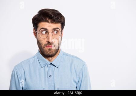 Foto di incredibile ragazzo indiano cercando lato spazio vuoto si sentono colpevoli per la terribile situazione, usura specs casual camicia denim bianco isolato colore di sfondo Foto Stock