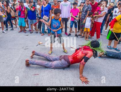 Filippino uomo si fa brivare durante un buon Venerdì crocifissione re-enactment a Pampanga nelle Filippine Foto Stock