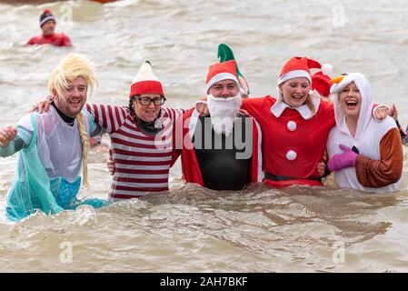Giubileo Beach, Marine Parade, Southend on Sea, Essex, Regno Unito. Come è ormai diventata una tradizione in località balneari, un 'Boxing Day Dip" ha avuto luogo a freddo, ruvida estuario del Tamigi a Southend la raccolta di fondi per il RNLI. Molti dei coraggiosi nuotatori indossavano abbigliamento festivo Foto Stock