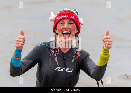 Giubileo Beach, Marine Parade, Southend on Sea, Essex, Regno Unito. Come è ormai diventata una tradizione in località balneari, un 'Boxing Day Dip" ha avuto luogo a freddo, ruvida estuario del Tamigi a Southend la raccolta di fondi per il RNLI. Molti dei coraggiosi nuotatori indossavano abbigliamento festivo Foto Stock