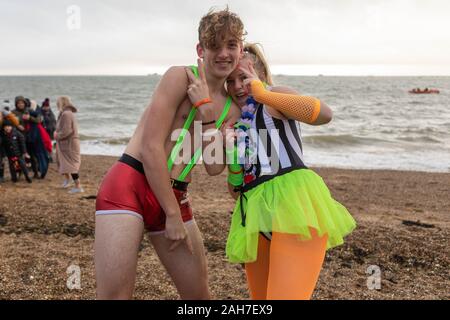 Jubilee Beach, Southend-on-Sea, Regno Unito. 26 dicembre 2019. Due partecipanti in abiti colorati e fantasiosi si mettono in posa a Jubilee Beach, Southend-on-Sea, Essex, prima dell'annuale giornata di Santo Stefano tuffandosi nelle fredde acque dell'estuario del Tamigi. L'evento benefico raccoglie fondi per il RNLI e offre nuotatori che affrontano le condizioni invernali in costumi festivi. Penelope Barritt/Alamy Live News Foto Stock