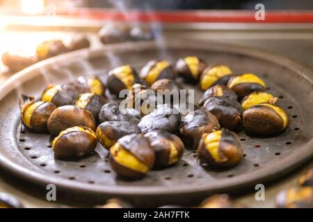 Close up di castagne arrostite in vendita su strada in inverno. Street food concept. Foto Stock