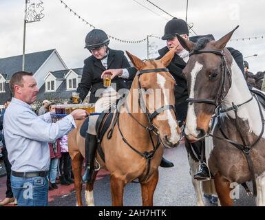 Carrigaline, Cork, Irlanda. 26 dicembre, 2019. Bar keeper Brendan Morrissey di Rosies Bar offre Toddies caldi ai membri del sud Unione Hunt prima dell'inizio della tradizionale il giorno di Santo Stefano, caccia su Main Street, Carrigaline, Co. Cork, Irlanda. - Credito; David Creedon / Alamy Live News Foto Stock