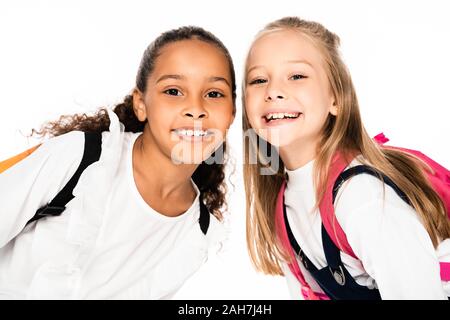 Due adorabili studentesse multiculturale sorridere mentre guardando la telecamera isolato su bianco Foto Stock