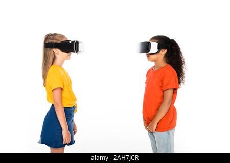 Due amici multiculturale guardando ogni altro mentre utilizzando la realtà virtuale auricolari isolato su bianco Foto Stock