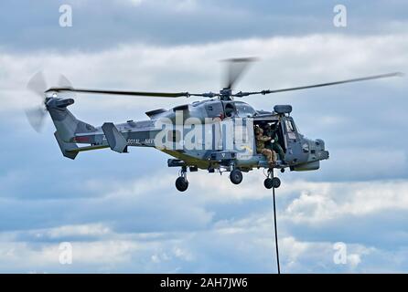 AgustaWestland AW159 Wildcat HMA2 aleggia come marines fast-corda a terra Foto Stock