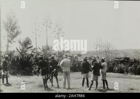 Kenya, sei uomini, le spalle alla telecamera, che guardano verso la foresta in cerca dei Mau Mau combattenti. I due uomini in uniforme sulla sinistra sono dalla polizia del Kenya, l uomo europeo nel mezzo è il quartiere officer e i tre uomini di destra sono Kikuyu Home protezioni, 1953. 1995/076/1/1/15/1.30. Foto Stock