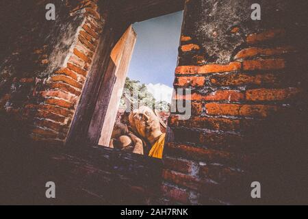 Wat Phutthaisawan Buddha reclinato in Ayutthaya Thailandia. Patrimonio UNESCO destinazione . vista attraverso la finestra resti del tempio antico.travel e explorat Foto Stock