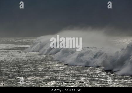 Dark tardo autunno seascape con lunga ondata di spruzzatura prima della tempesta. Costa portoghese. Foto Stock
