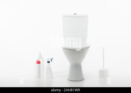 Pulire ceramica tazza WC vicino a spazzola per WC e di materiali per la pulizia isolato su bianco Foto Stock