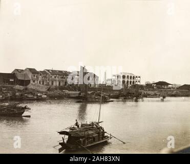 La Cina, un sampan viaggia lungo il Fiume Xijiang al Sam Shui, passando una stringa di imbarcazioni ormeggiate lungo la riva del fiume.manoscritto originale didascalia: Sam Shui. A ovest del fiume. 90 miglia da Cantone, ora collegato con la ferrovia, circa 1906. 1998/028/1/1/110. Foto Stock