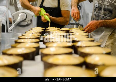 Chef pastoso chef adulto forte preparare e decorare panettone per la cottura , un dolce pane natalizio tipico di Milano Foto Stock