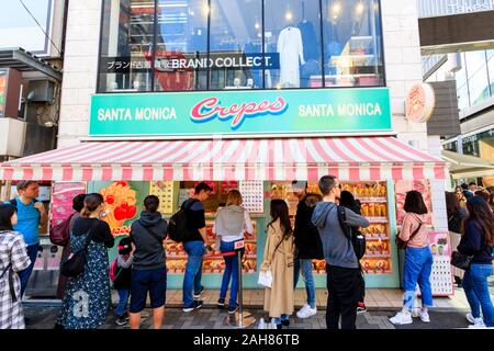 Giapponese e i turisti stranieri in coda al di fuori della famosa Santa Monica Crepes takeaway off Takeshita Street a Harajuku di Tokyo. Ore diurne. Foto Stock