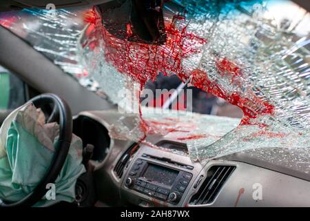 Broken auto parabrezza dopo un incidente con tracce di sangue e airbag. vista dall'interno Foto Stock
